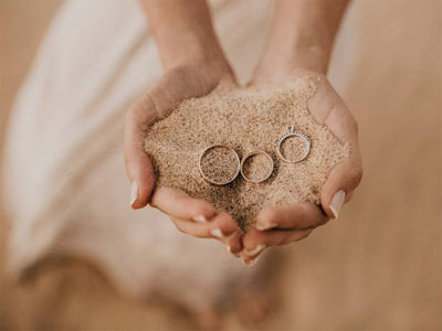 Trouwringen in een hand vol zand
